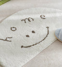Clement Smiley Face Plush Accent Rug - Neutral Tones, Lofted Plush Pile with a Coated Grip Backing, Soft Bedside Mat