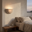 Emory stone wall lamp above a bedside table