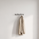 Bram three-hook wave wall coat rack on a bedroom wall