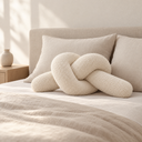 Knotted Bolster Cushion in White styled in a bedroom