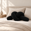 Knotted Bolster Cushion in Black styled in a bedroom